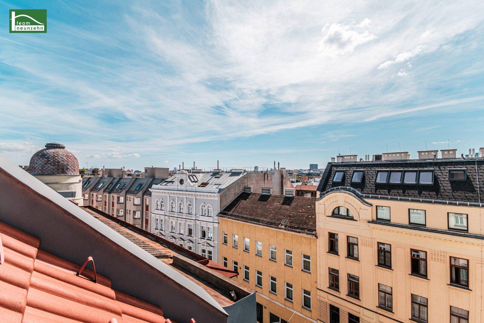 Panoramablick über die Dächer der Stadt mit historischen Gebäuden und weitem Horizont.