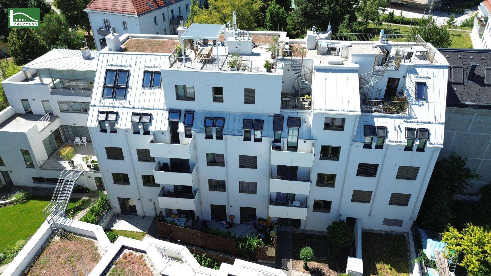 Luftaufnahme einer modernen Wohnanlage mit Dachterrassen, Balkonen und begrünten Dächern.