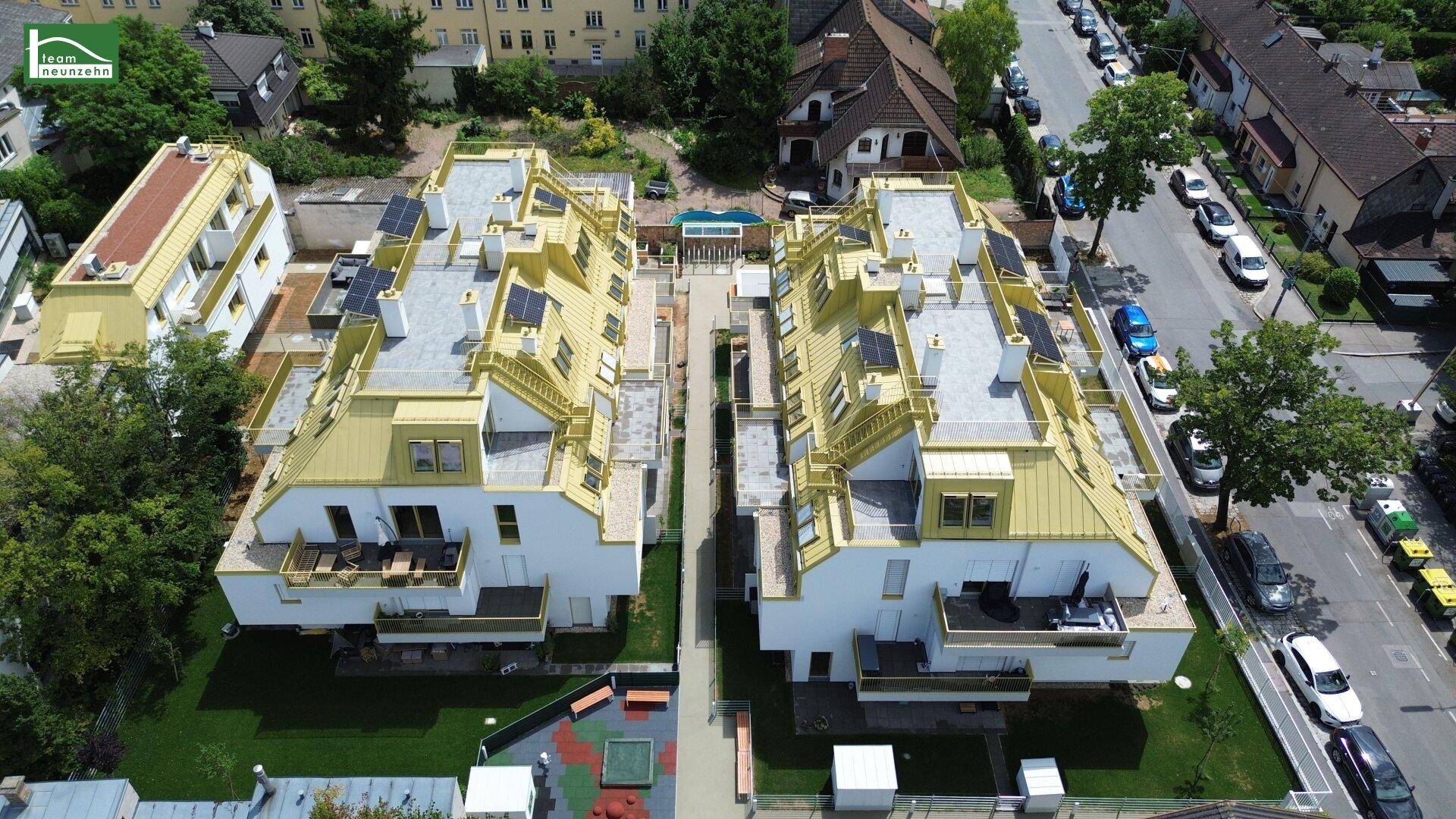 Gesamtansicht der modernen Wohnanlage von oben mit Grünflächen und Spielplatz.