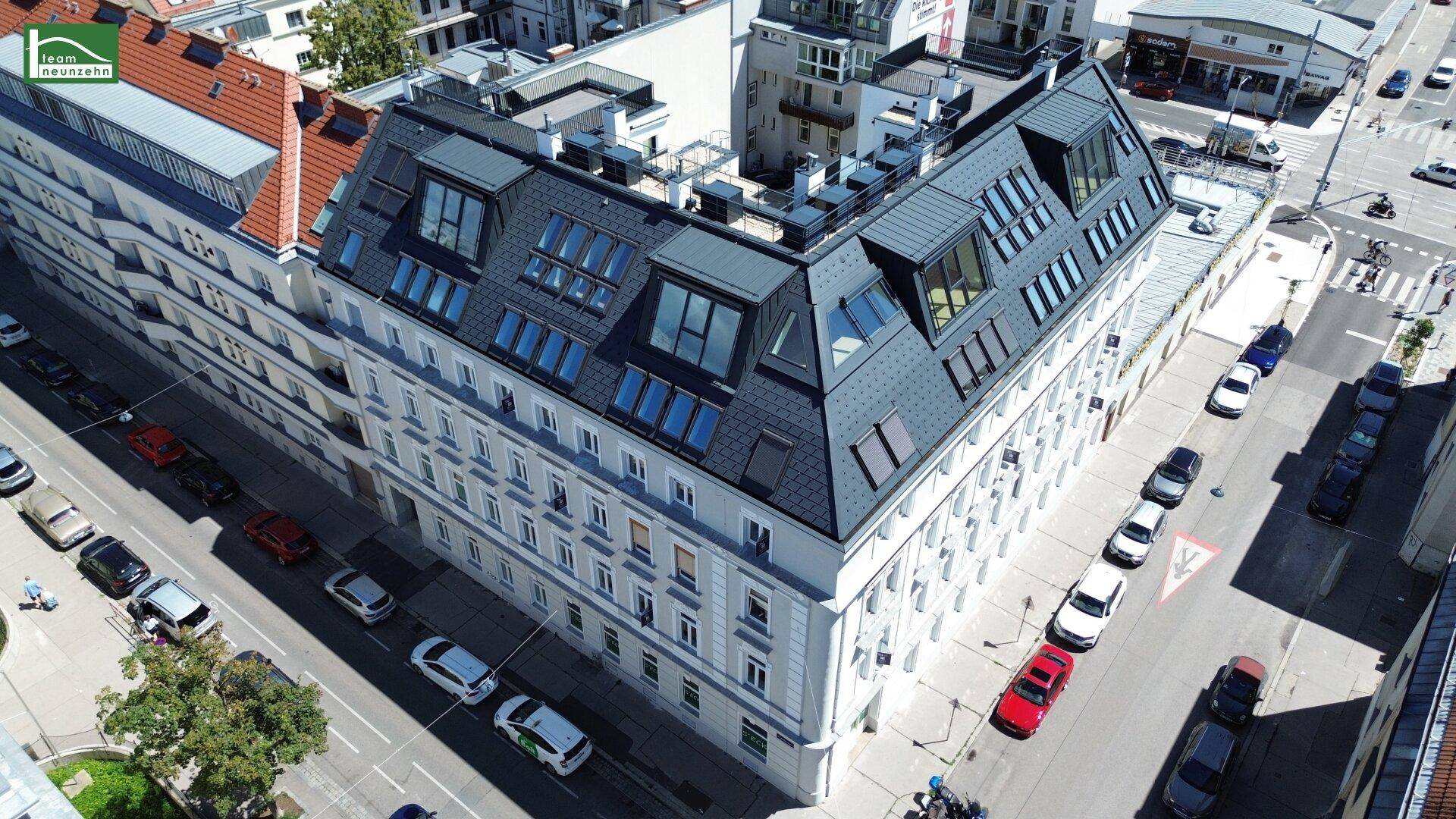Vogelperspektive des sanierten Altbaus und der weiten Stadtlandschaft mit Fernblick.