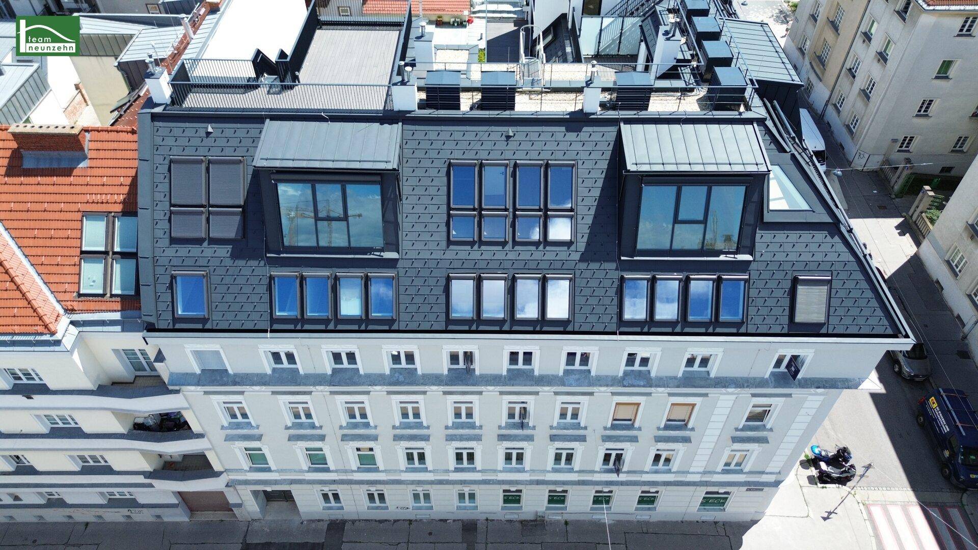 Dachansicht des Gebäudes mit modernen Dachfenstern und Dachterrassenbereichen.