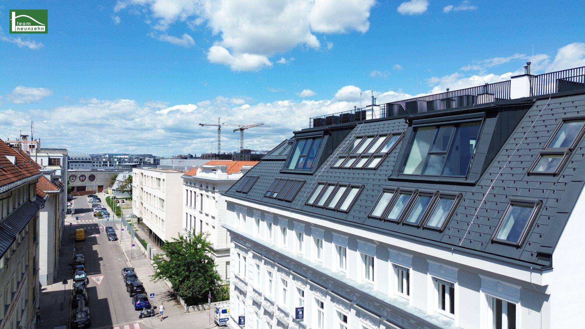 Detailansicht des modernen Dachgeschosses eines Altbaus mit vielen Dachfenstern.