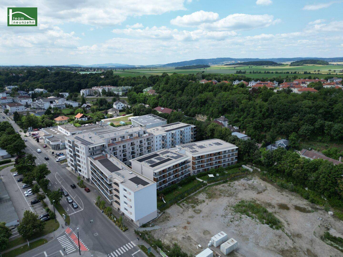 Weitläufige Luftaufnahme des Wohnkomplexes in einer grünen, städtischen Umgebung.