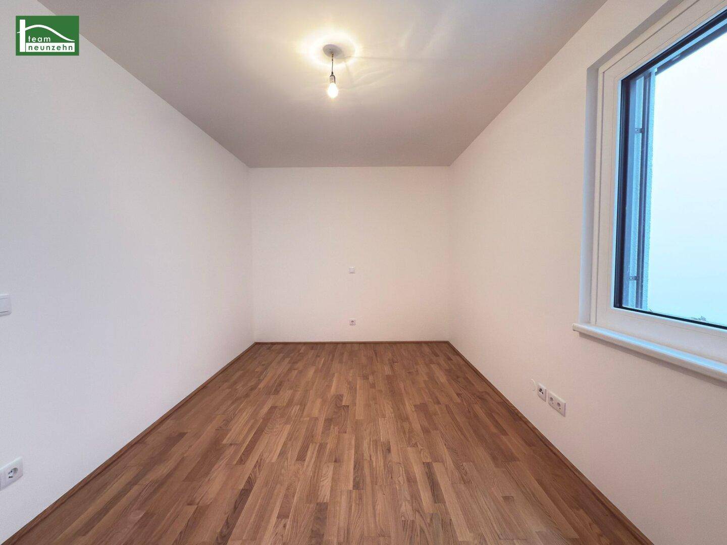 Leeres Zimmer mit Holzparkett und Fenster, ideal als Schlaf- oder Arbeitszimmer nutzbar.