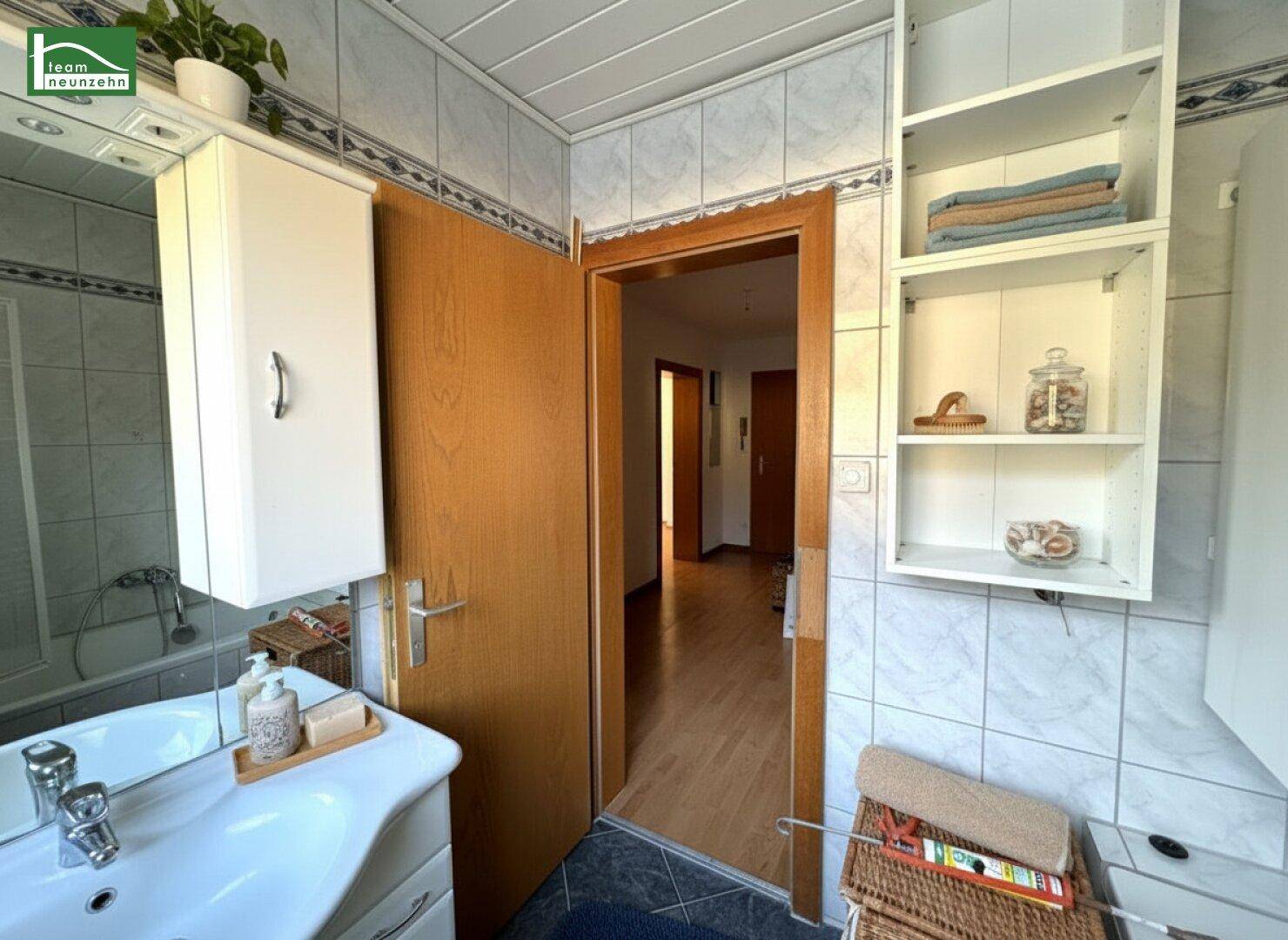 Badezimmer mit Waschbecken, Spiegelschrank und Badewanne.