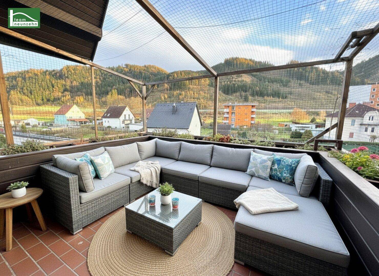 Große möblierte Terrasse mit Bergblick und gemütlicher Sitzecke.