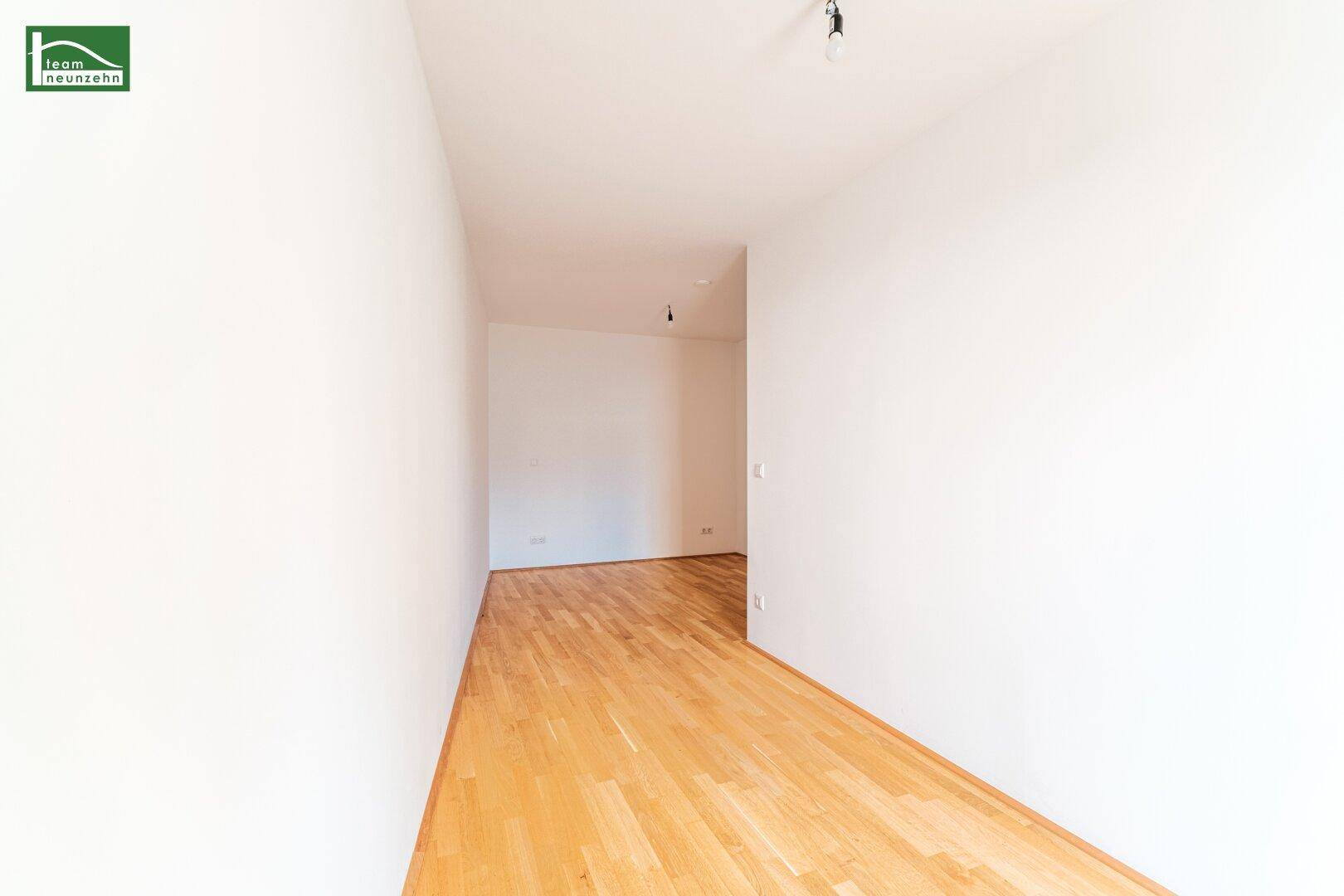 Heller Flur mit Holzboden, der zu weiteren Räumen in der Wohnung führt.