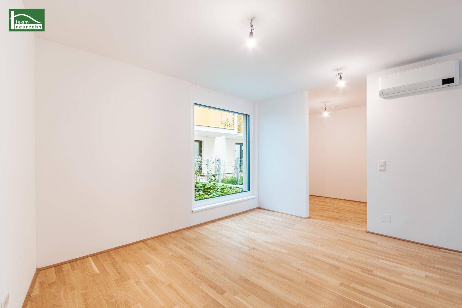 Heller Raum mit großem Fenster und Holzboden, ideal als Wohn- oder Essbereich nutzbar.