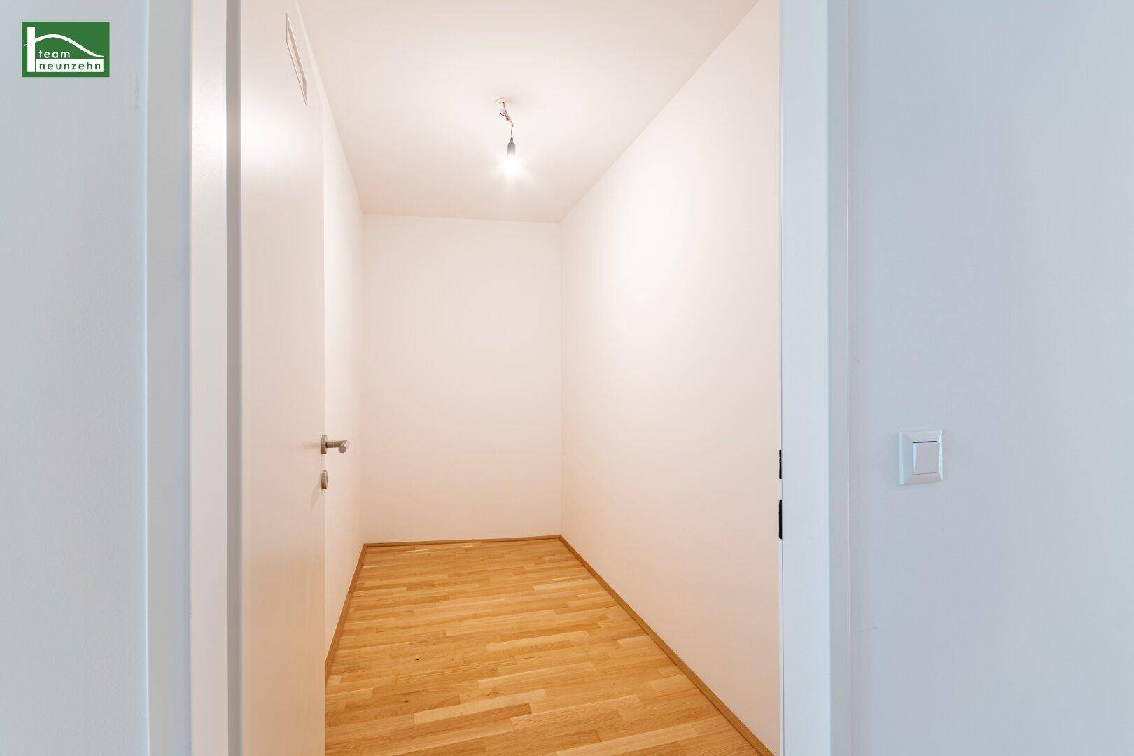 Praktischer Abstellraum mit Holzboden und weißen Wänden, ideal für zusätzlichen Stauraum.