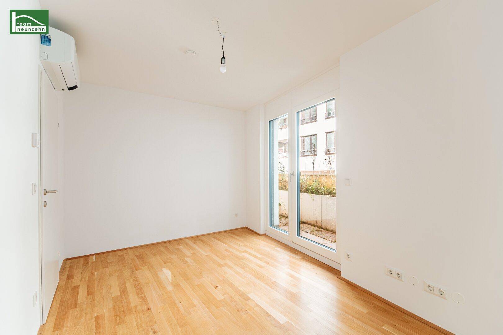 Geräumiges Schlafzimmer mit Parkettboden und großen Fenstern, ideal für natürliche Belichtung.