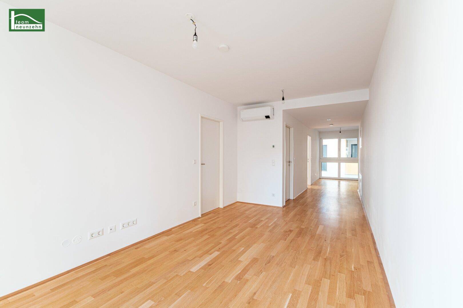 Geräumiges, helles Zimmer mit Parkettboden und Blick auf den grünen Innenhof.
