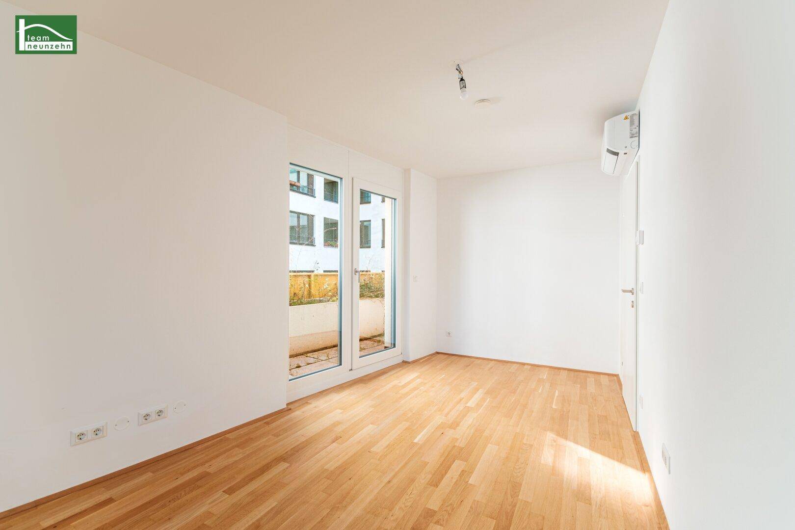 Geräumiges Schlafzimmer mit Parkettboden und großen Fenstern, ideal für natürliche Belichtung.
