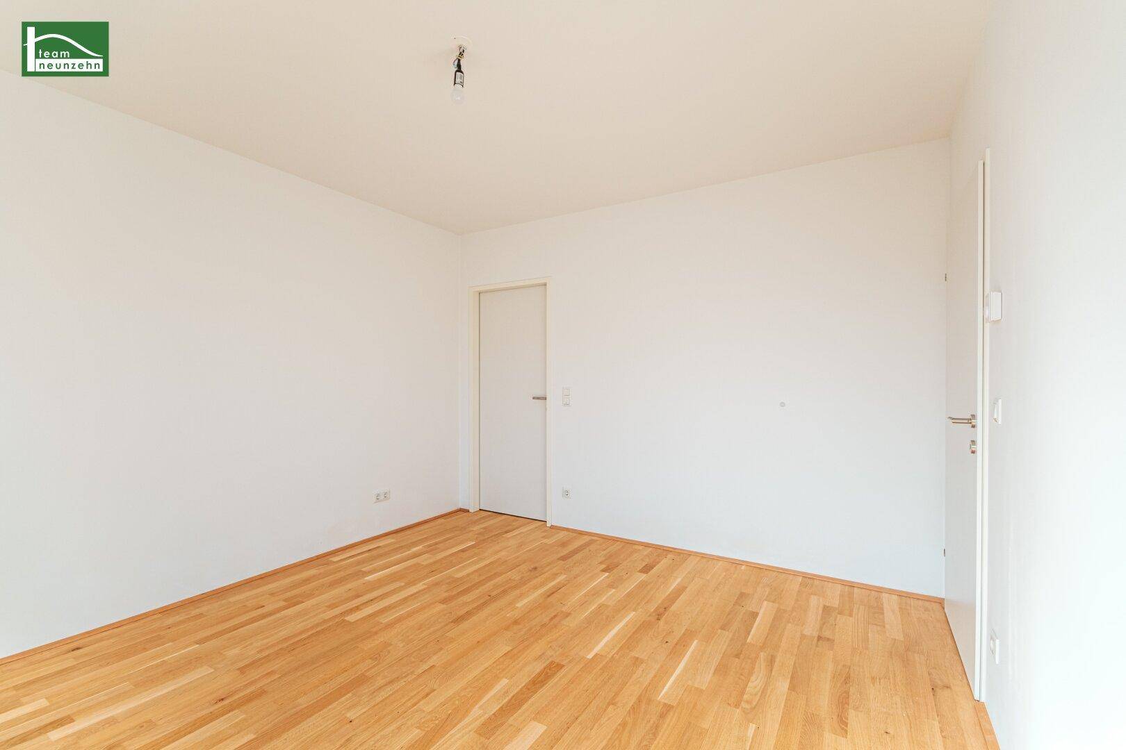 Leeres Zimmer mit Parkettboden und weiß gestrichenen Wänden, ideal für individuelle Gestaltung.