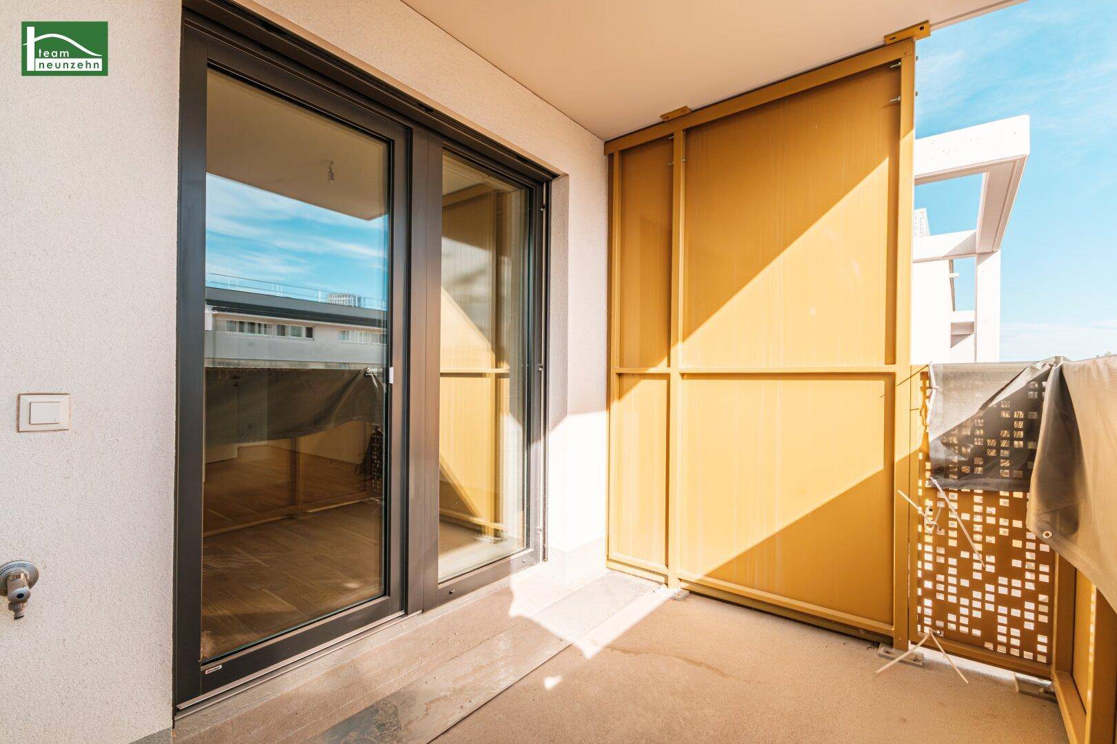 Sonniger Balkon mit Schiebetür und gelben Sichtschutzelementen, ideal zum Entspannen.