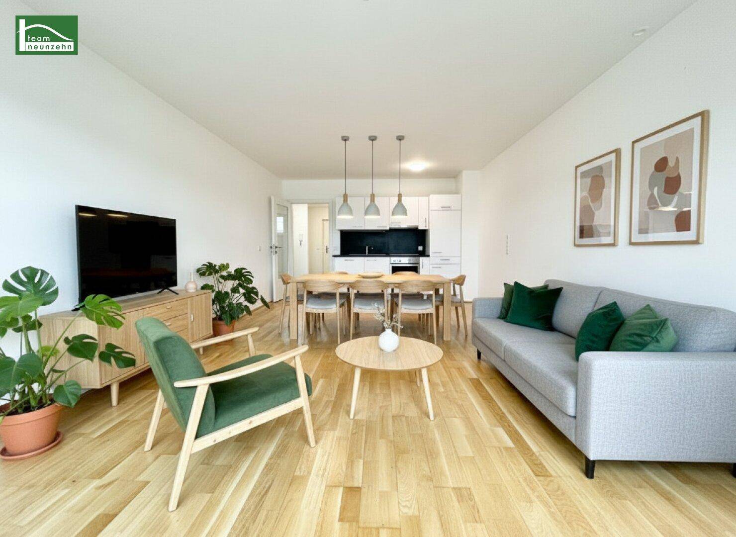 Modern eingerichteter Wohn- und Essbereich mit offener Küche und Holzboden.