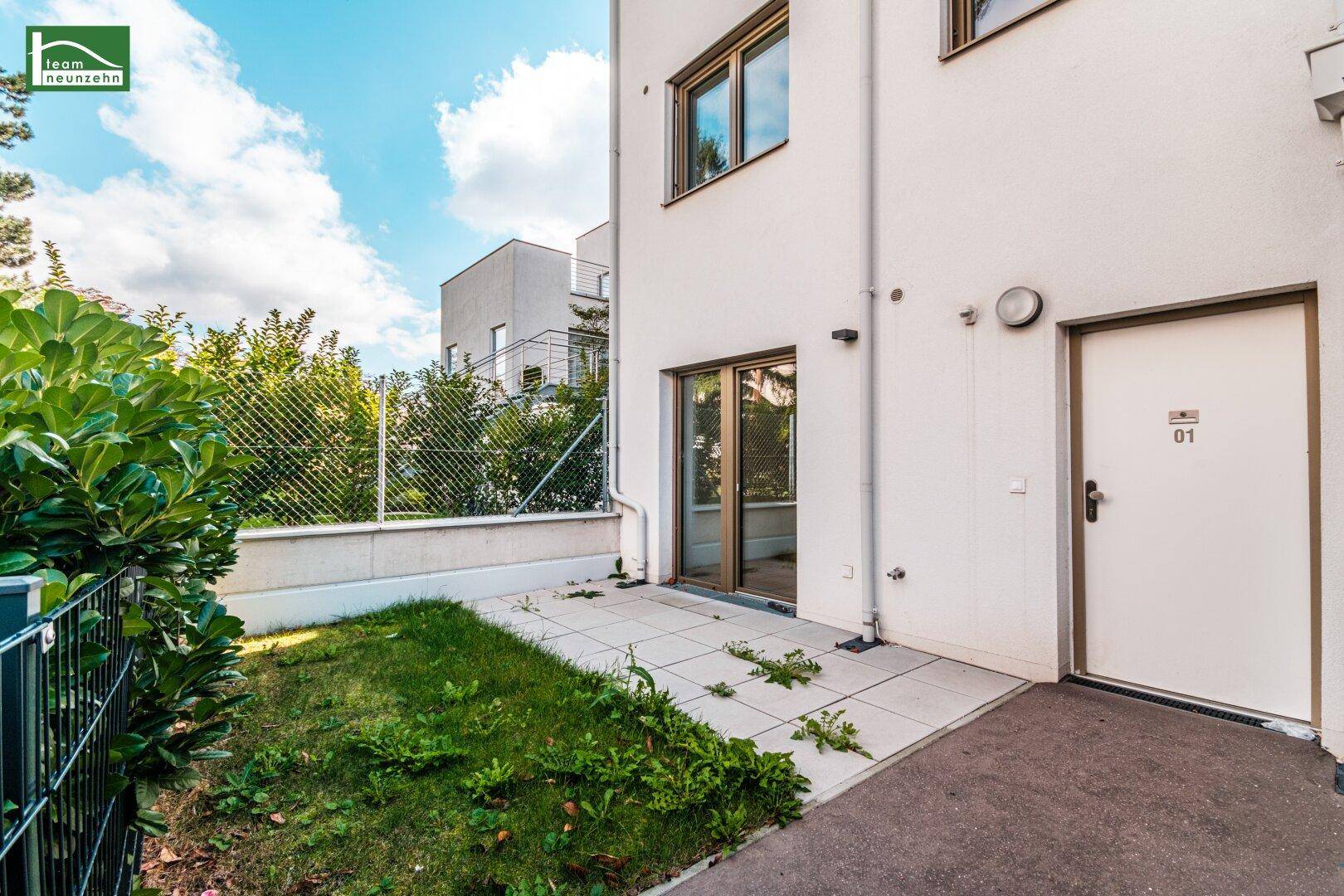 Kleiner Gartenbereich mit gepflasterter Terrasse und Zugang zu einer modernen Wohneinheit.
