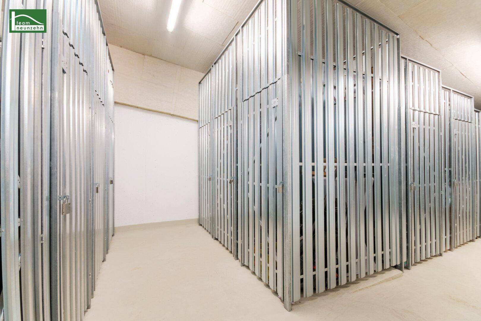 Reihen von individuellen Lagerabteilen aus Metall in einem Kellerraum.