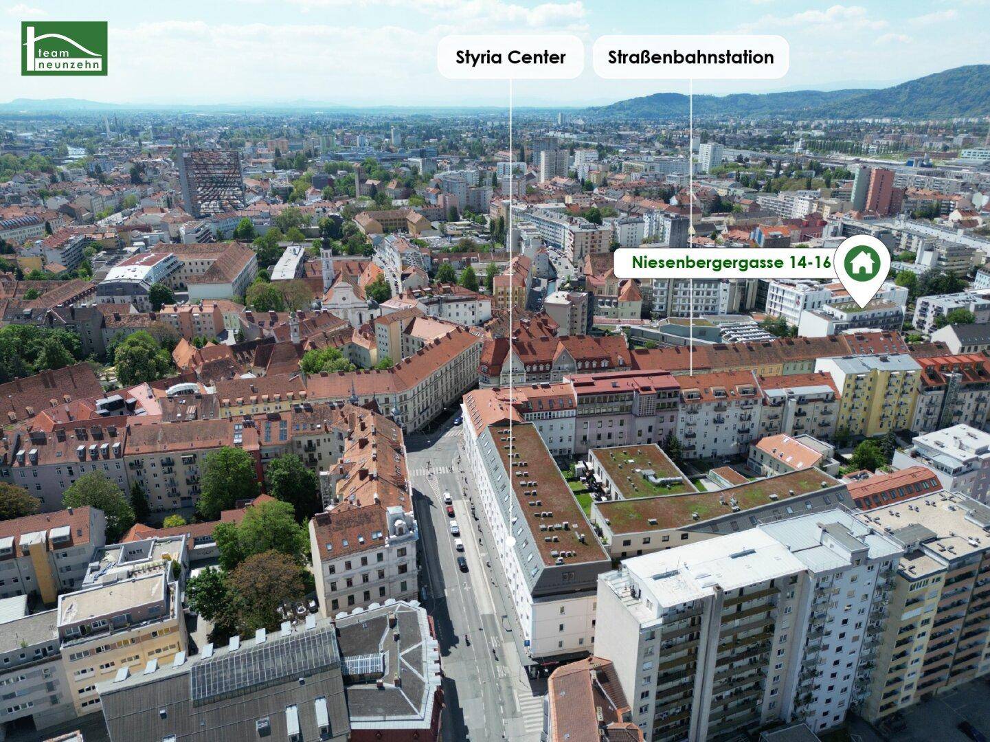 Stadtansicht aus der Vogelperspektive mit markiertem Wohngebäude und umliegender Infrastruktur.