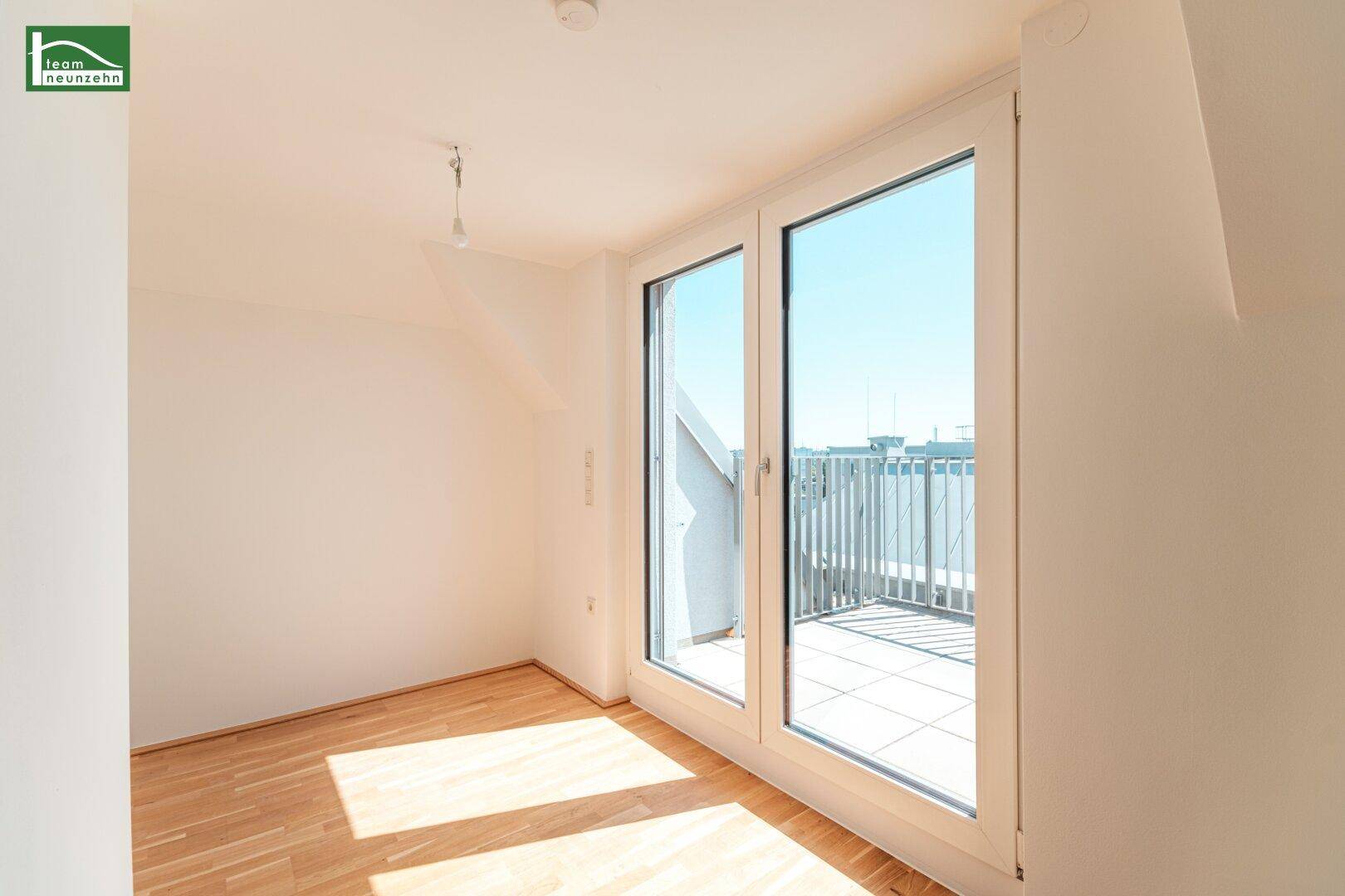 Helles Schlafzimmer mit Holzboden und großem Terrassenzugang, der viel Licht hereinlässt.