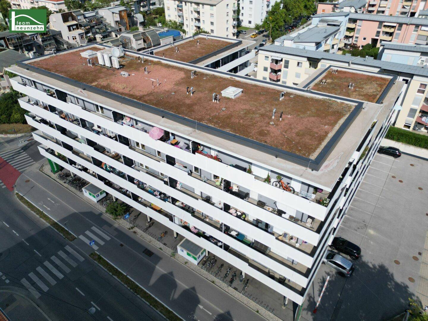 Luftaufnahme des modernen Wohnkomplexes mit begrünten Flachdächern und vielen Balkonen.