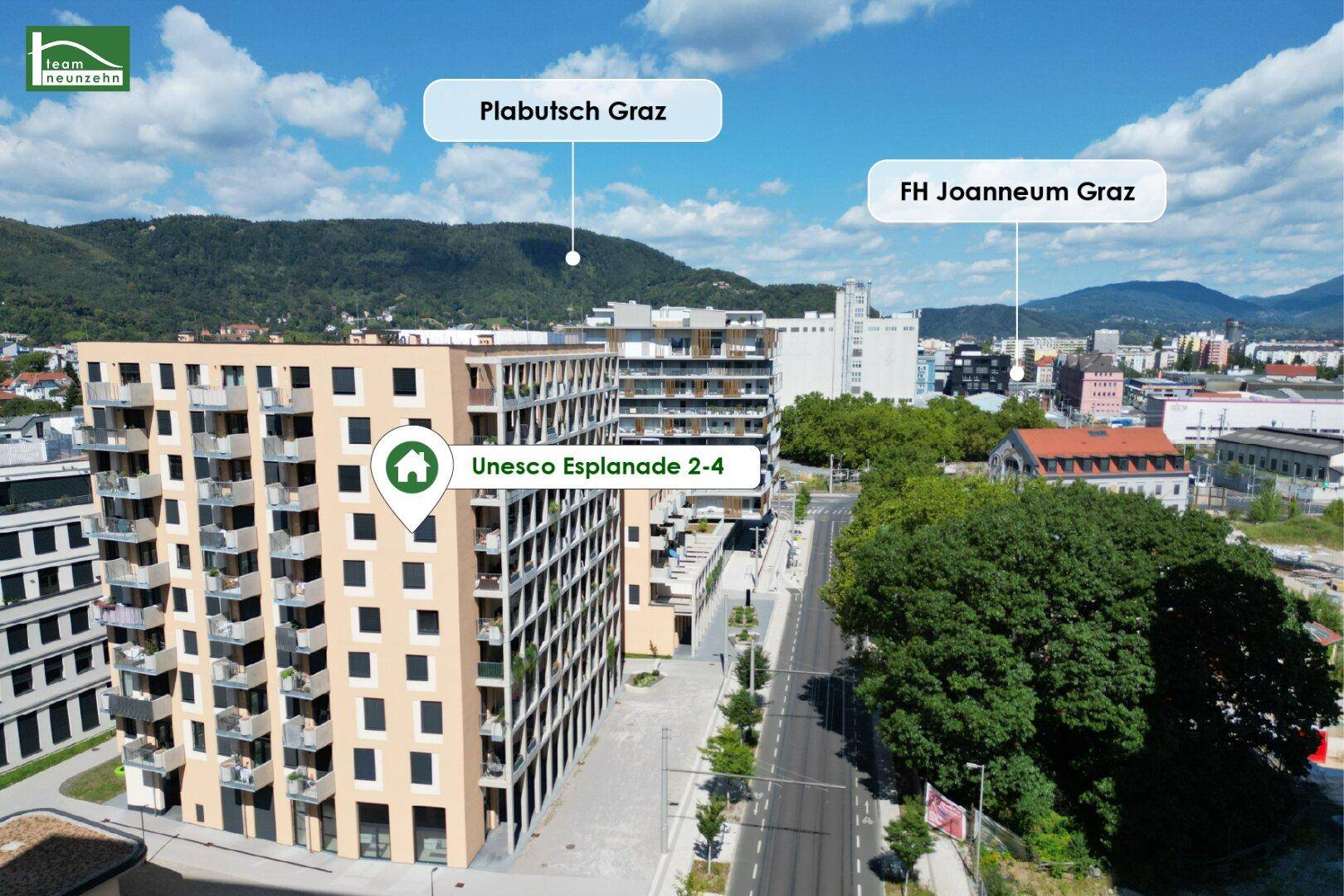 Luftaufnahme eines modernen Wohnkomplexes mit mehreren Gebäuden und umliegender Stadtlandschaft.