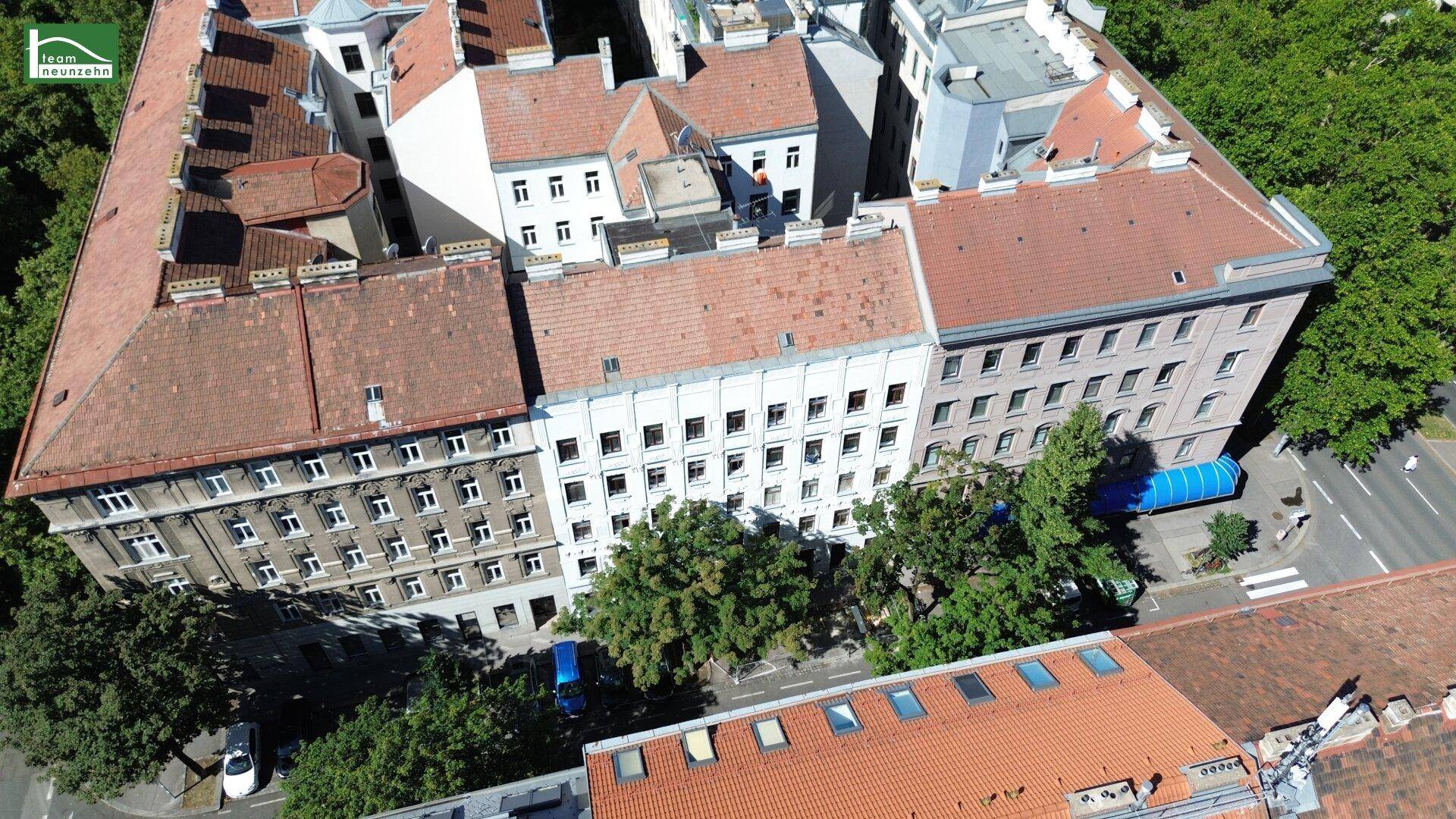 Luftaufnahme der Nachbarschaft mit Gebäuden, Bäumen und Straßen, die die Umgebung zeigen.
