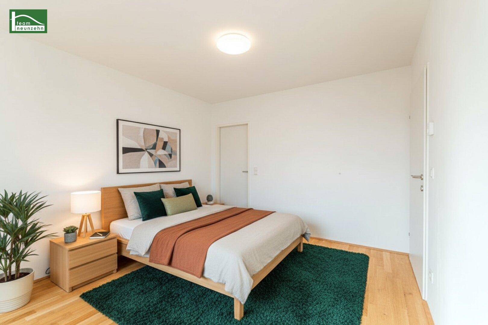 Gemütliches Schlafzimmer mit Holzbett, Parkettboden und modernem, grünem Teppich.