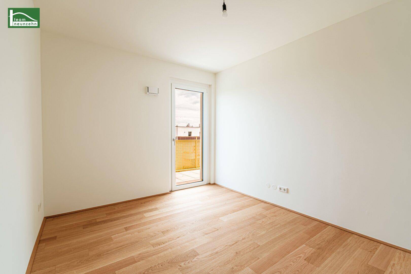 Helles Schlafzimmer mit Holzboden und Zugang zu einem Balkon, bereit zum Einrichten.