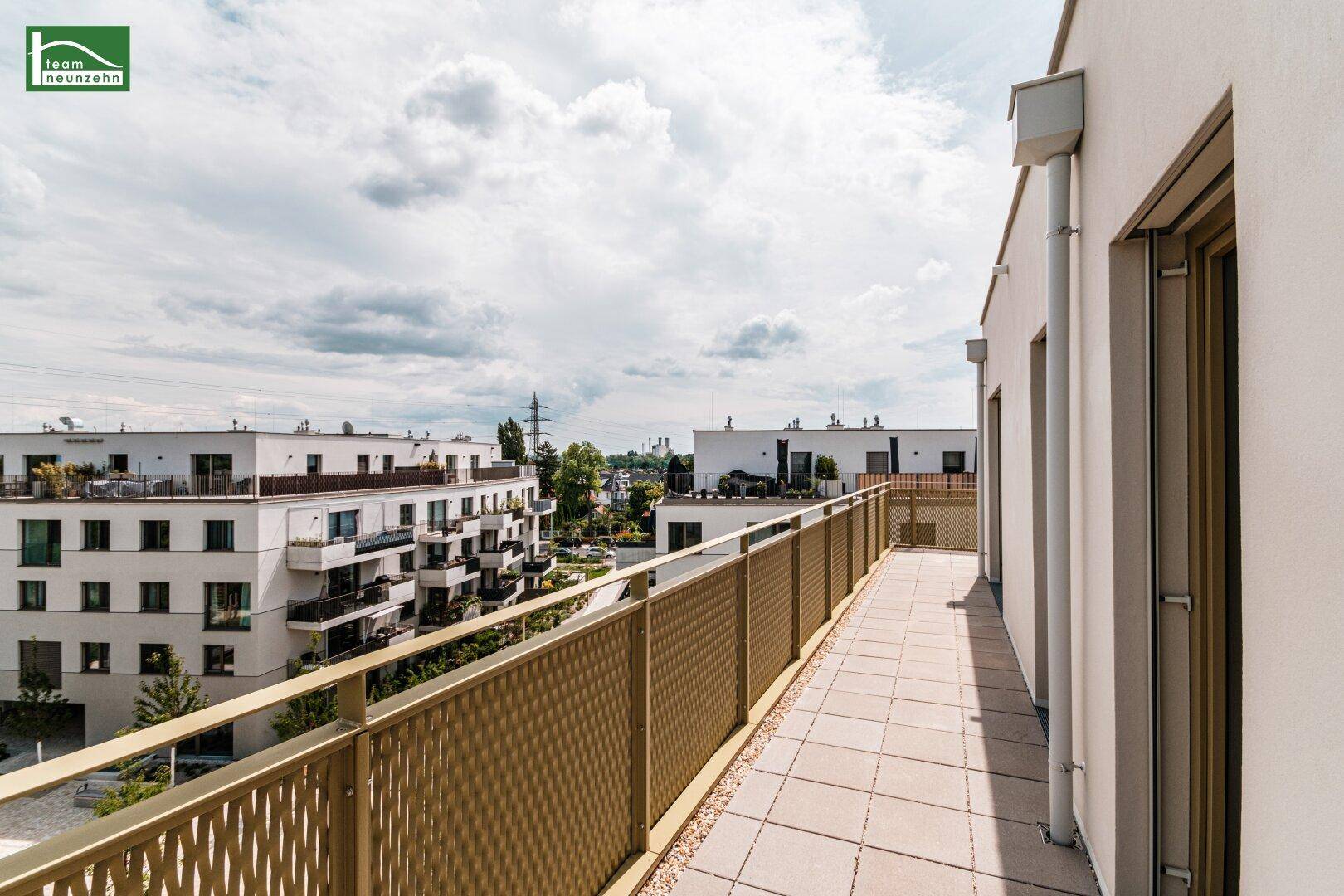 Langer Balkon mit Fliesenboden und Metallgeländer, bietet Blick auf die Umgebung.