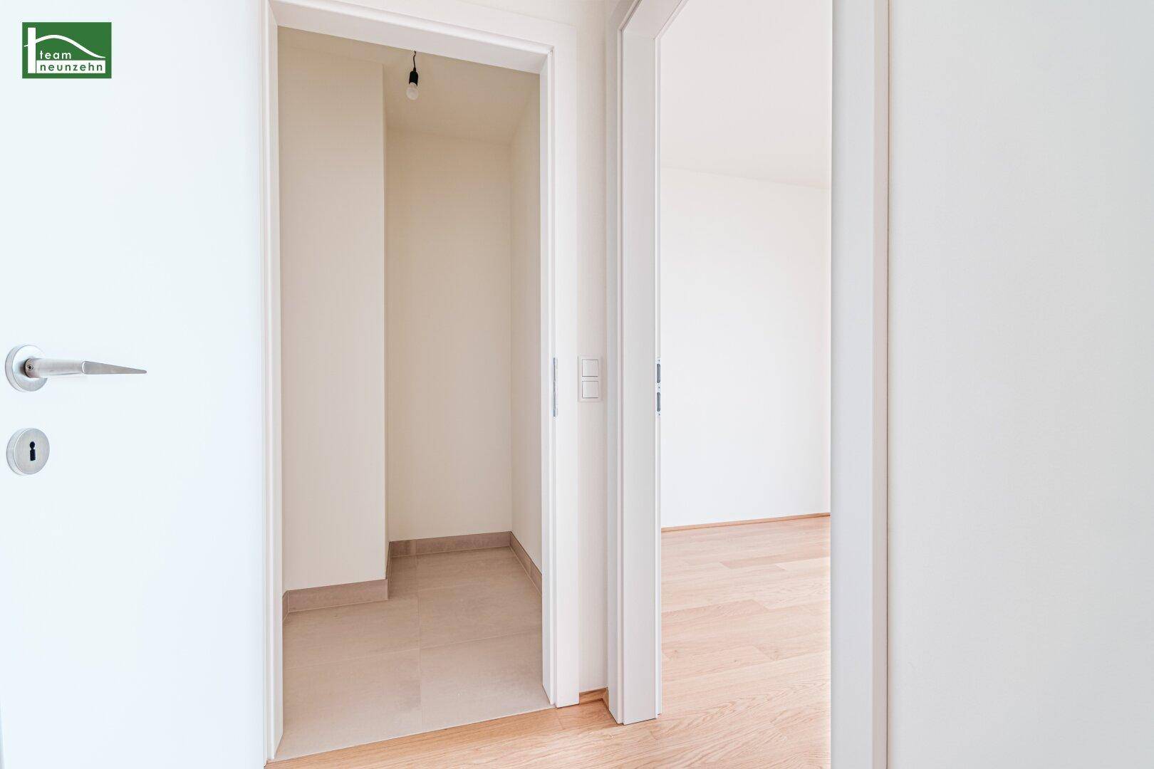 Heller Flur mit Holzboden und Zugang zu verschiedenen Räumen der Wohnung.