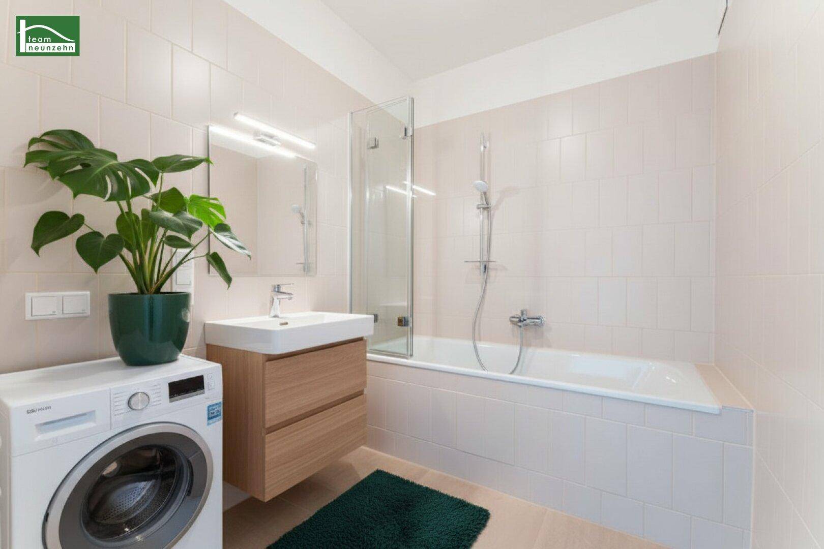 Funktionales Badezimmer mit Badewanne, Waschmaschine und modernem Waschtisch.