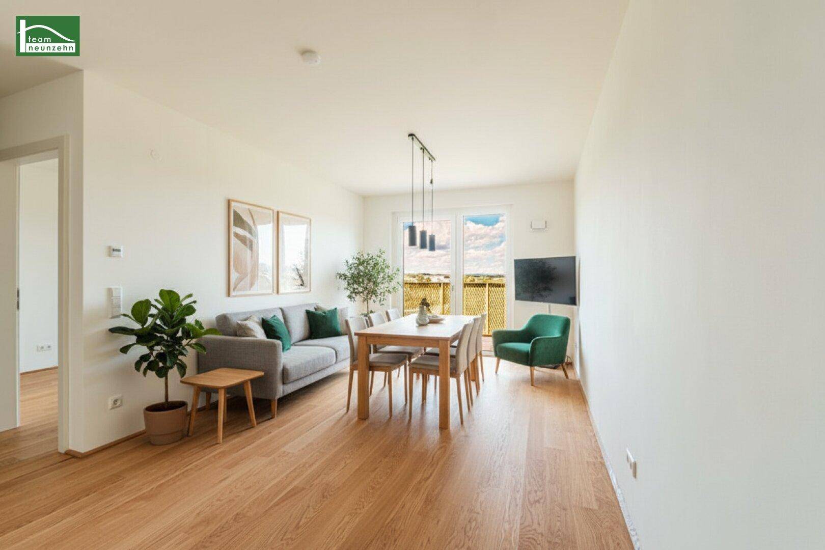 Gemütlicher Wohn-Essbereich mit Holzboden, Sofa und Esstisch, hell und modern eingerichtet.