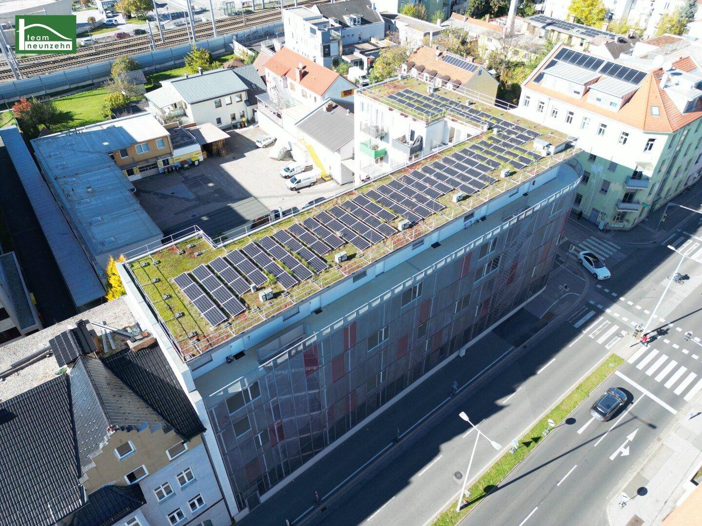 Luftaufnahme des Gebäudes mit Gründach und Photovoltaikanlage auf dem Dach.