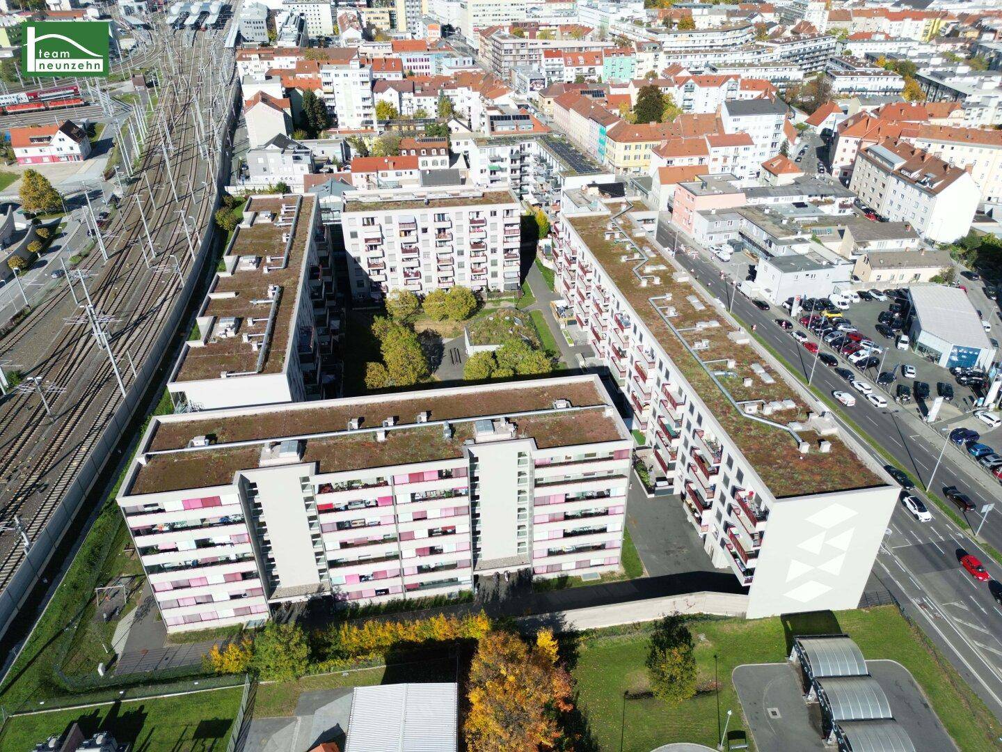 Weitläufige Wohnanlage mit begrünten Dächern und Innenhöfen, umgeben von städtischer Infrastruktur.