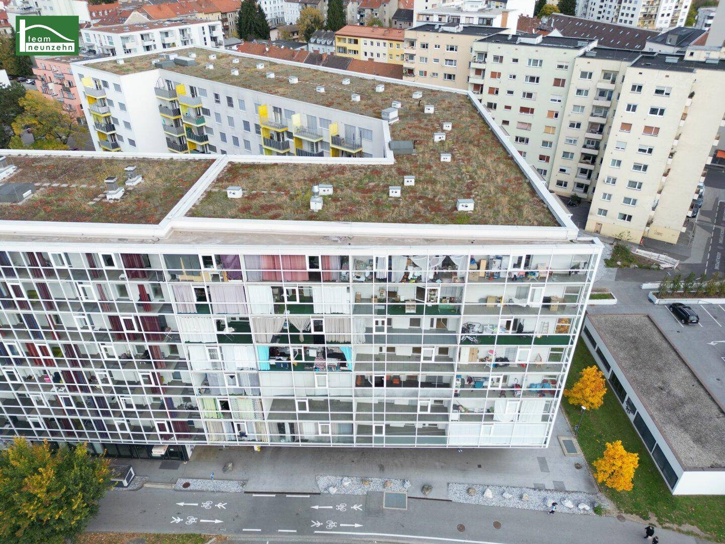 Moderne Wohngebäude mit begrünten Flachdächern und großen Fensterfronten.