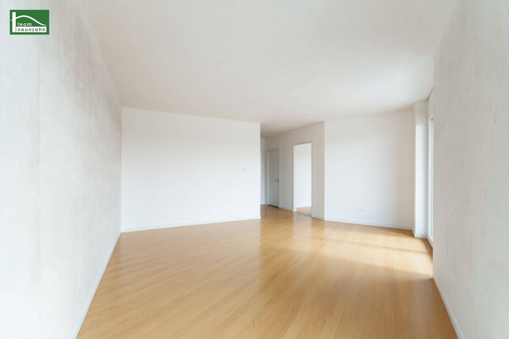 Geräumiger, heller Raum mit Holzboden und großen Fenstern, bereit zur individuellen Gestaltung.
