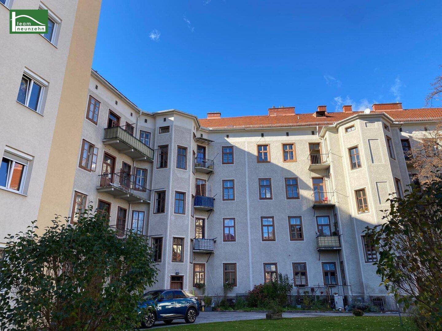 Historisches Gebäude mit zahlreichen Balkonen und Fenstern, die einen Innenhof umgeben.