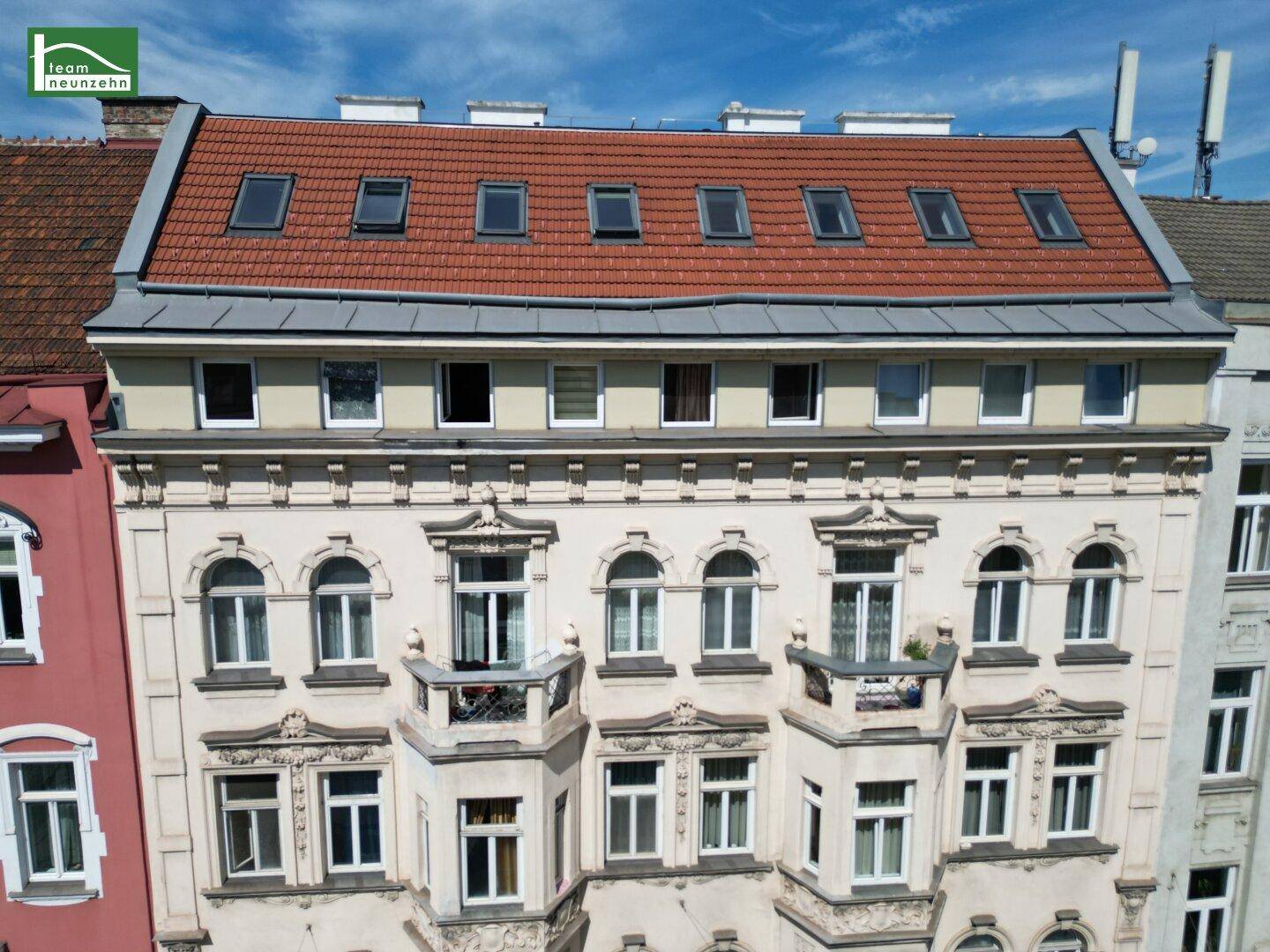 Historisches Wohngebäude mit Mansarddach und Dachfenstern, von oben fotografiert.
