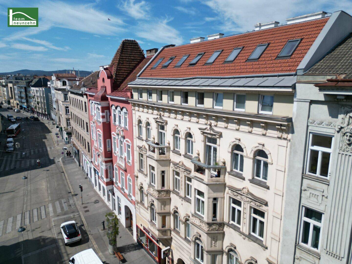 Weitläufige Luftaufnahme der Stadtstraße mit historischen Gebäuden und Verkehr.