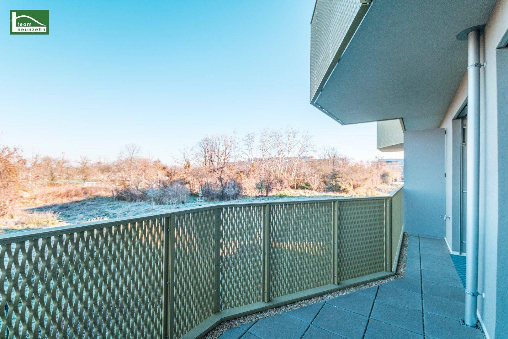 Moderner Balkon mit Fliesenboden und dekorativem Metallgeländer, bietet einen weiten Ausblick.