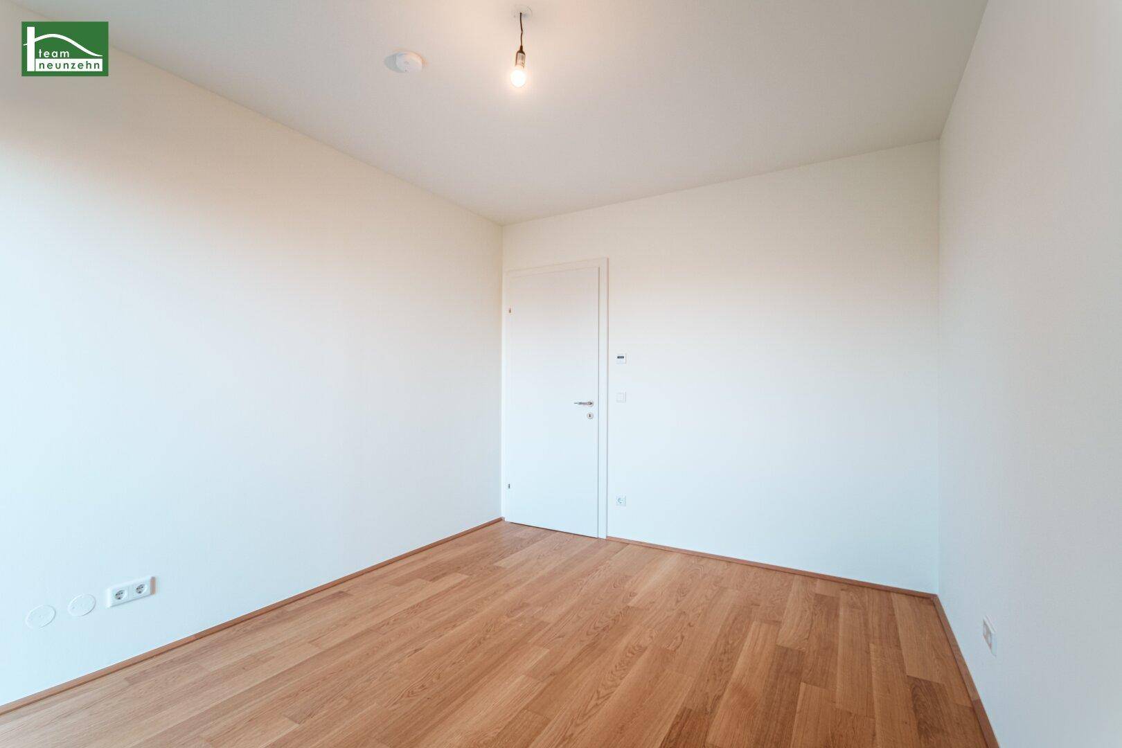 Unmöbliertes Zimmer mit Parkettboden und weiß gestrichenen Wänden, ideal als Schlafzimmer.
