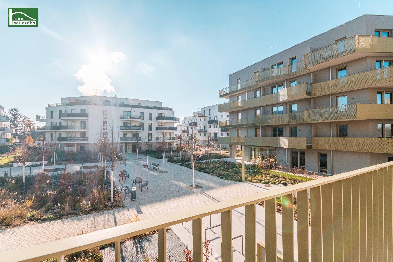 Terrasse mit Blick auf die gepflegte Grünanlage und weitere Wohngebäude.