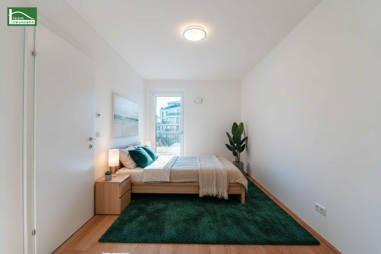Gemütliches Schlafzimmer mit Holzboden, weißer Einrichtung, grünem Teppich und Balkonzugang.