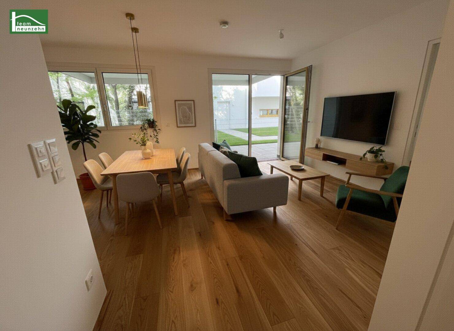 Modern eingerichteter Wohn-Essbereich mit Holzboden, Sofa und Esstisch, hell und einladend gestaltet.
