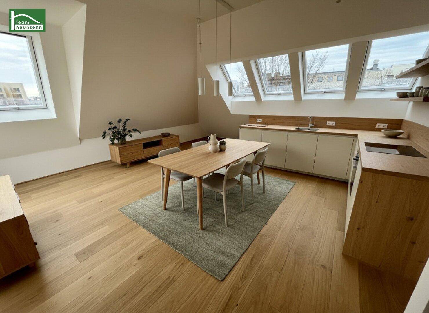 Offener Wohn-Essbereich mit Holzboden, moderner Küche und Dachfenstern, ideal für geselliges Beisammensein.