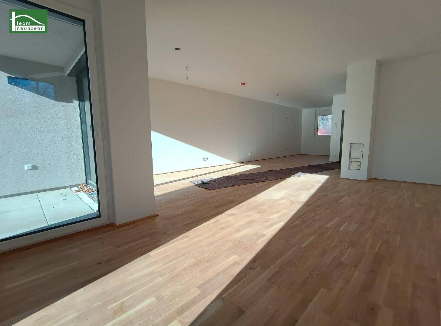 Großzügiger, offener Wohnbereich mit Parkettboden und viel Tageslicht.