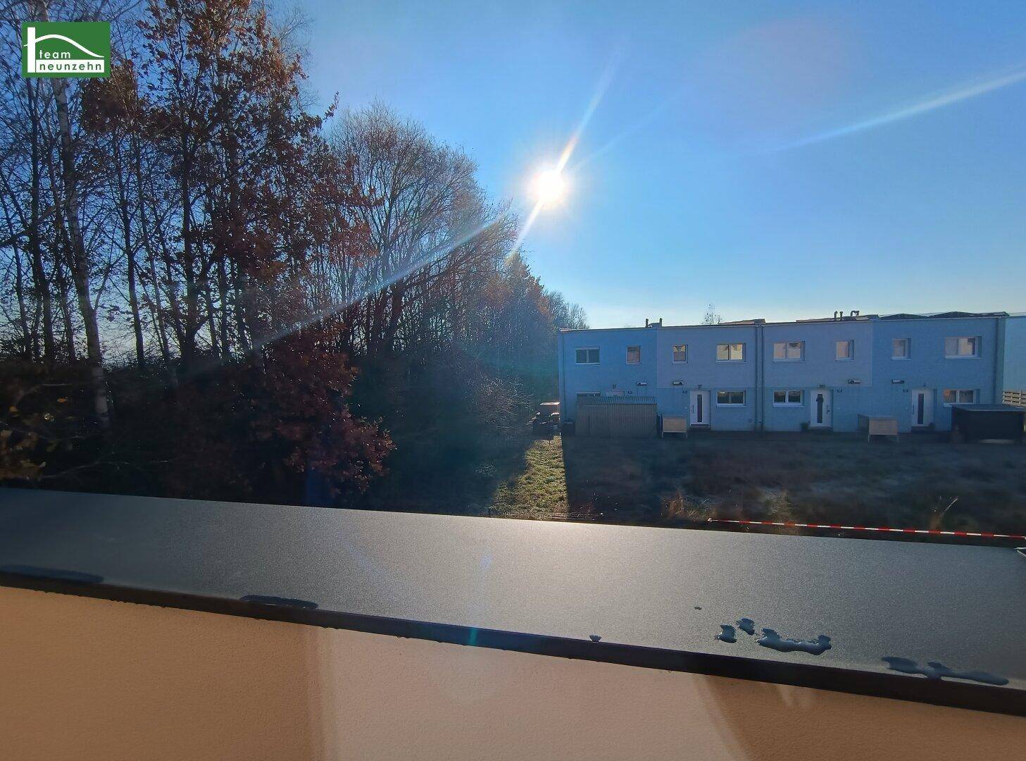 Weitblick über die Umgebung mit neuen Reihenhäusern unter strahlendem Himmel.