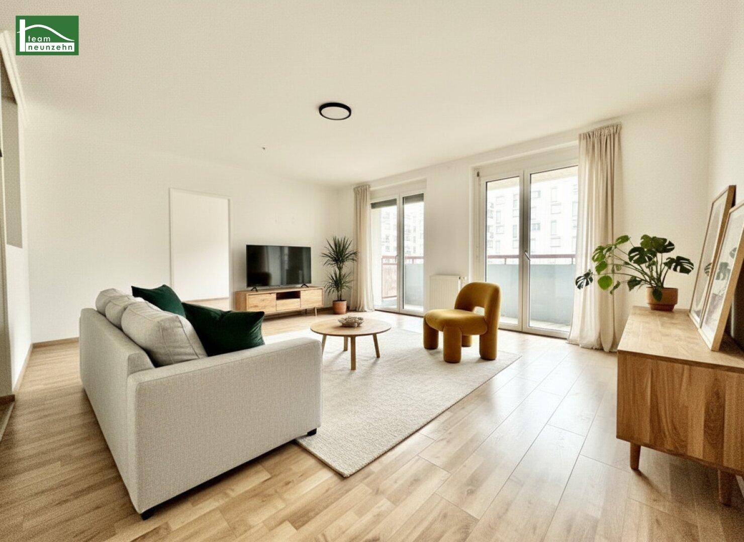 Helles, modernes Wohnzimmer mit Holzboden, großen Fenstern und Zugang zu einem Balkon.