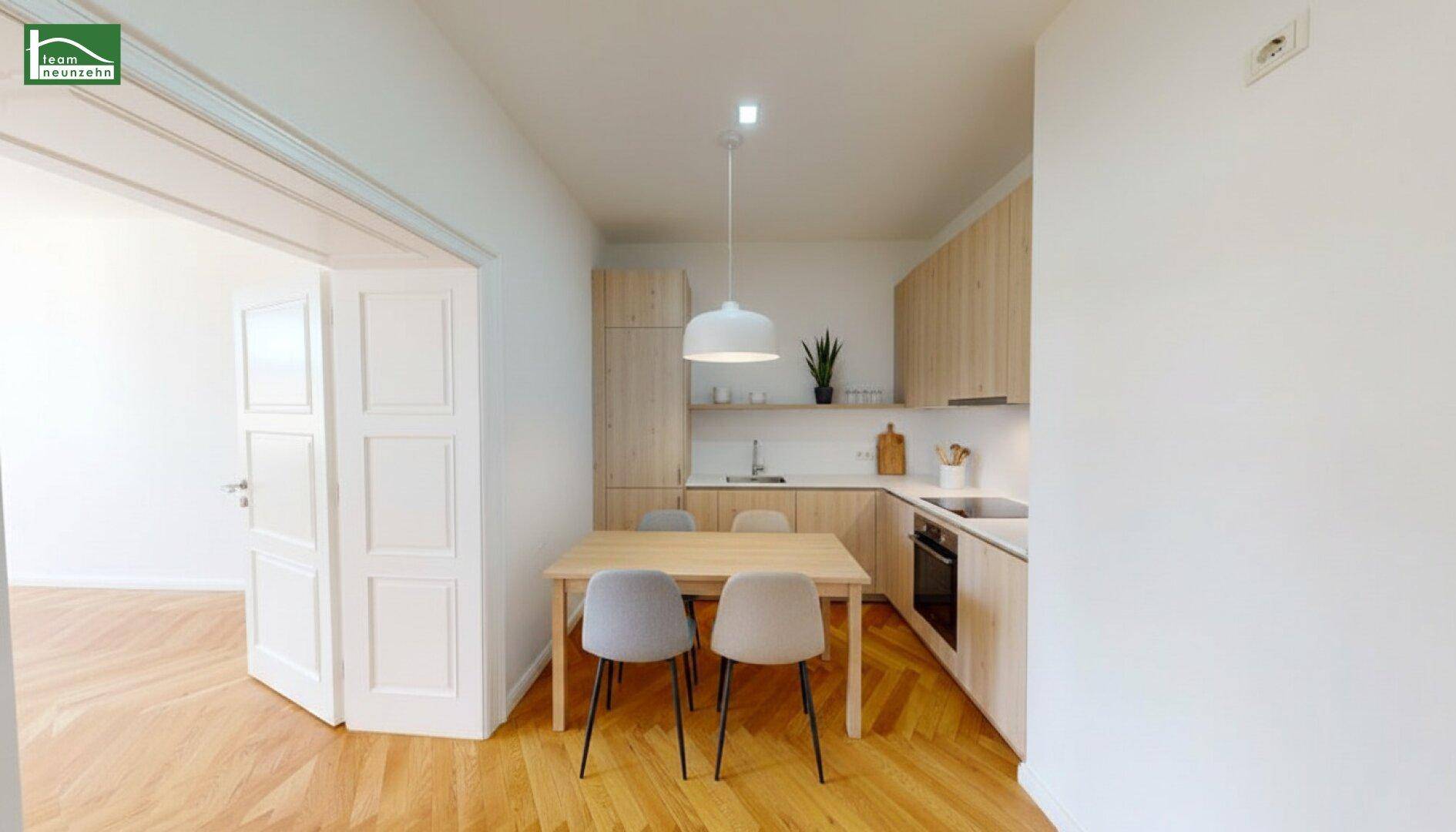Moderne Einbauküche mit hellen Holzfronten und Essbereich, ausgestattet mit Parkettboden.