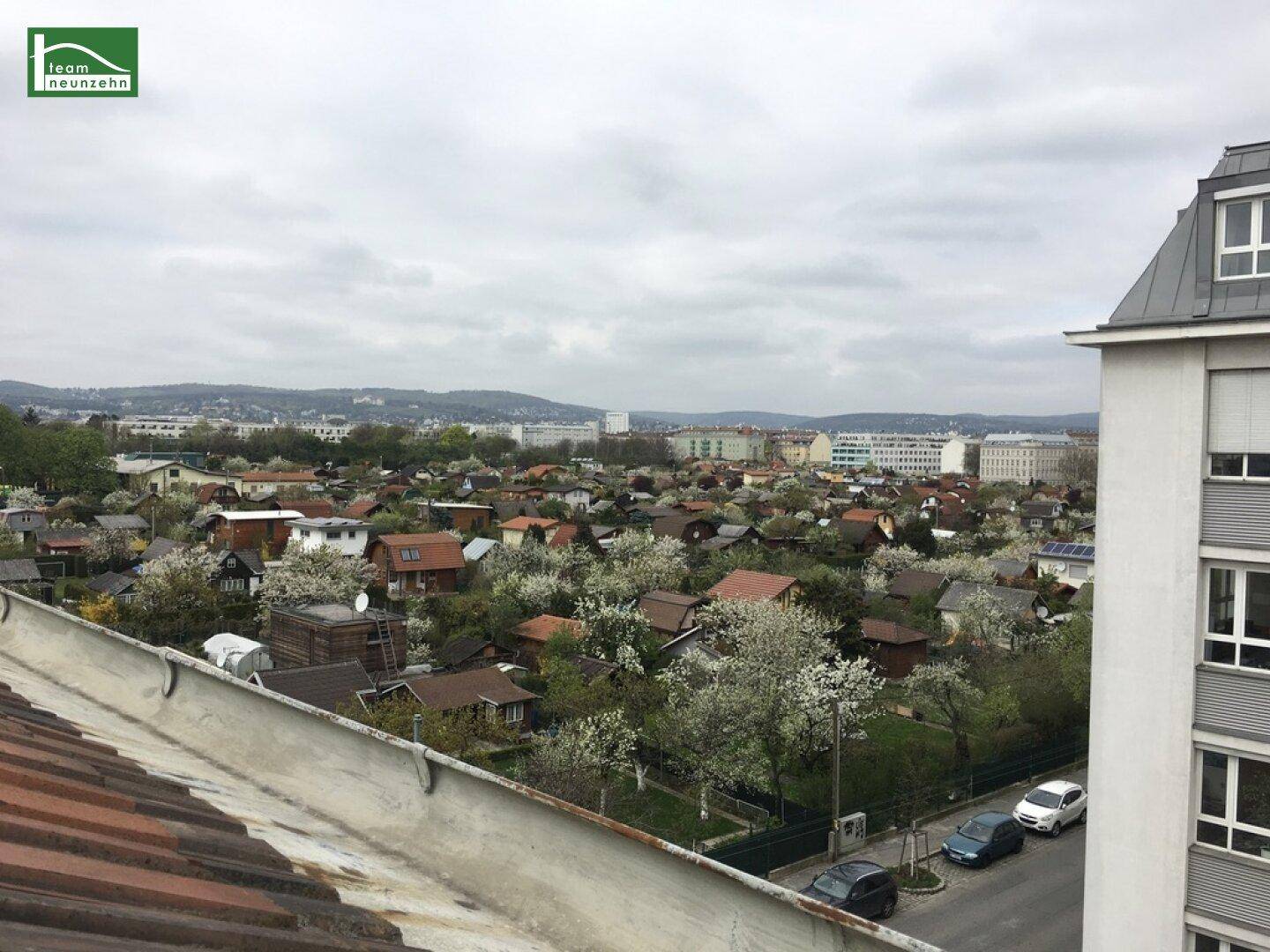 Blick über Dächer und Gärten einer Vorstadt an einem bewölkten Frühlingstag.